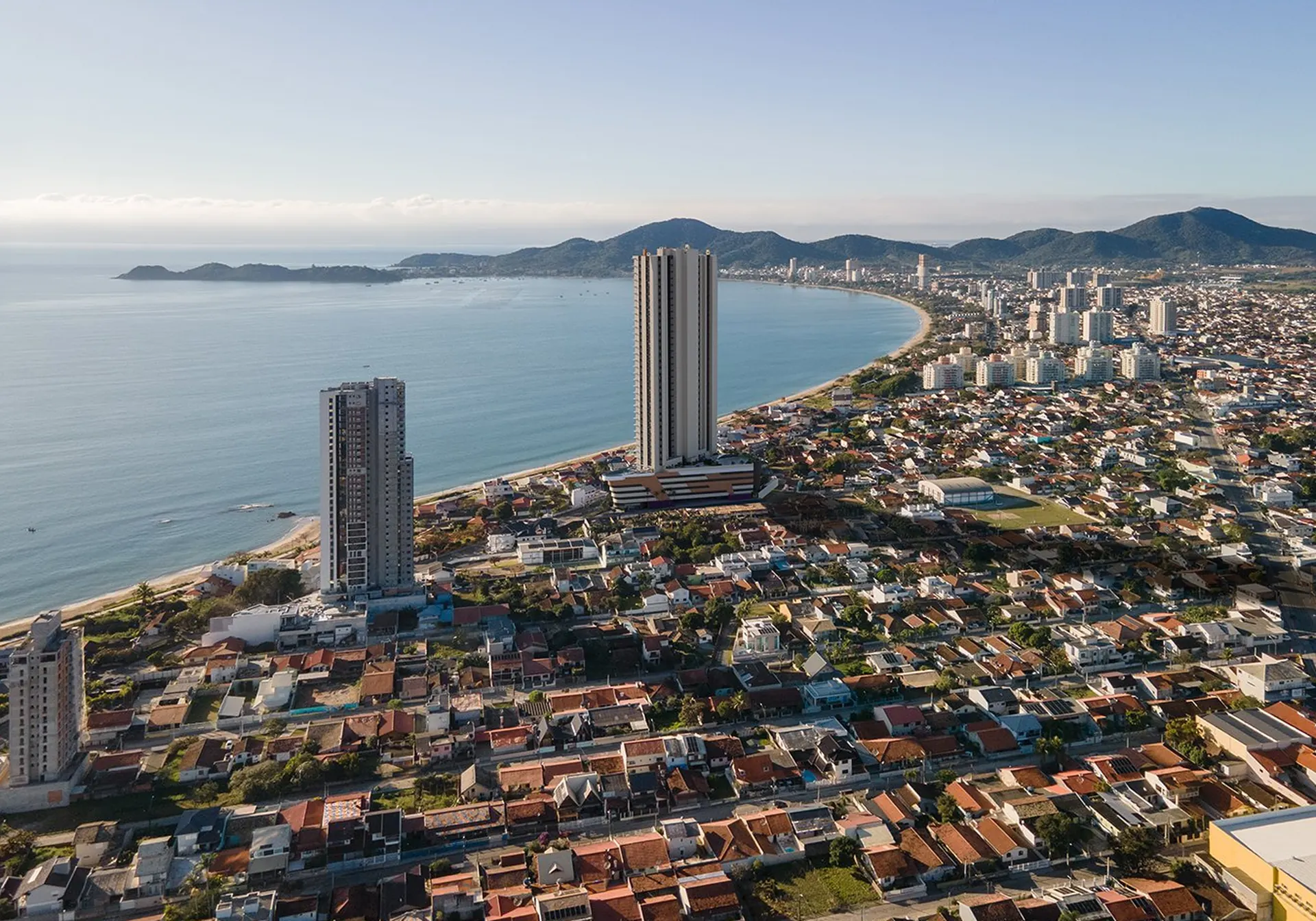 Vista aérea do litoral norte de Santa Catarina: baía, orla e serra